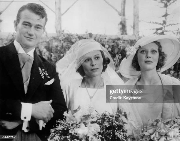 Film actor John Wayne on his wedding day with his wife Josephine Saenz and Loretta Young .