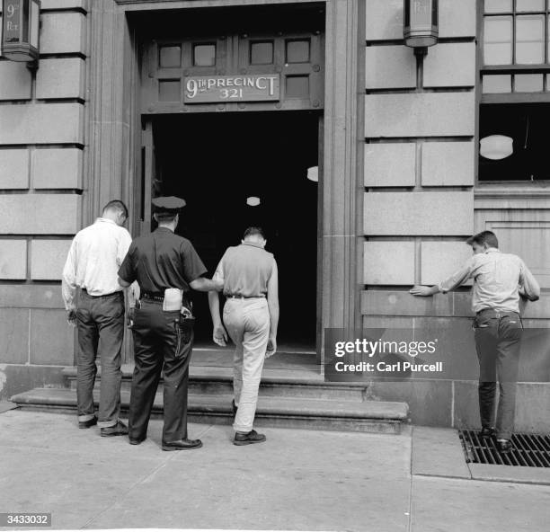 Two members of a teenage street gang are taken into the 9th Precinct police station after their arrest in New York City.