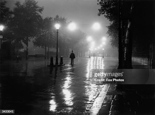 London policeman finds himself without any traffic to direct on a rainy night on the River Thames Embankment between Chelsea and Westminster.