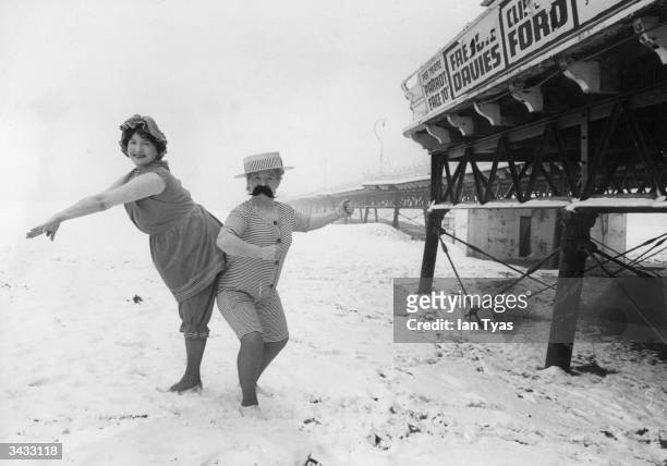 Skegness landladies Hazel Adams and Marjorie Romanis wearing 1914 bathing costumes on the beach in the snow for publicity photographs.