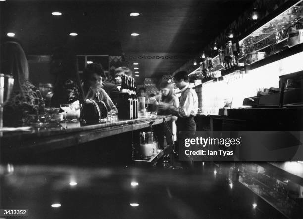 People drinking at the bar of The Speakeasy nightclub near Oxford Circus, London.