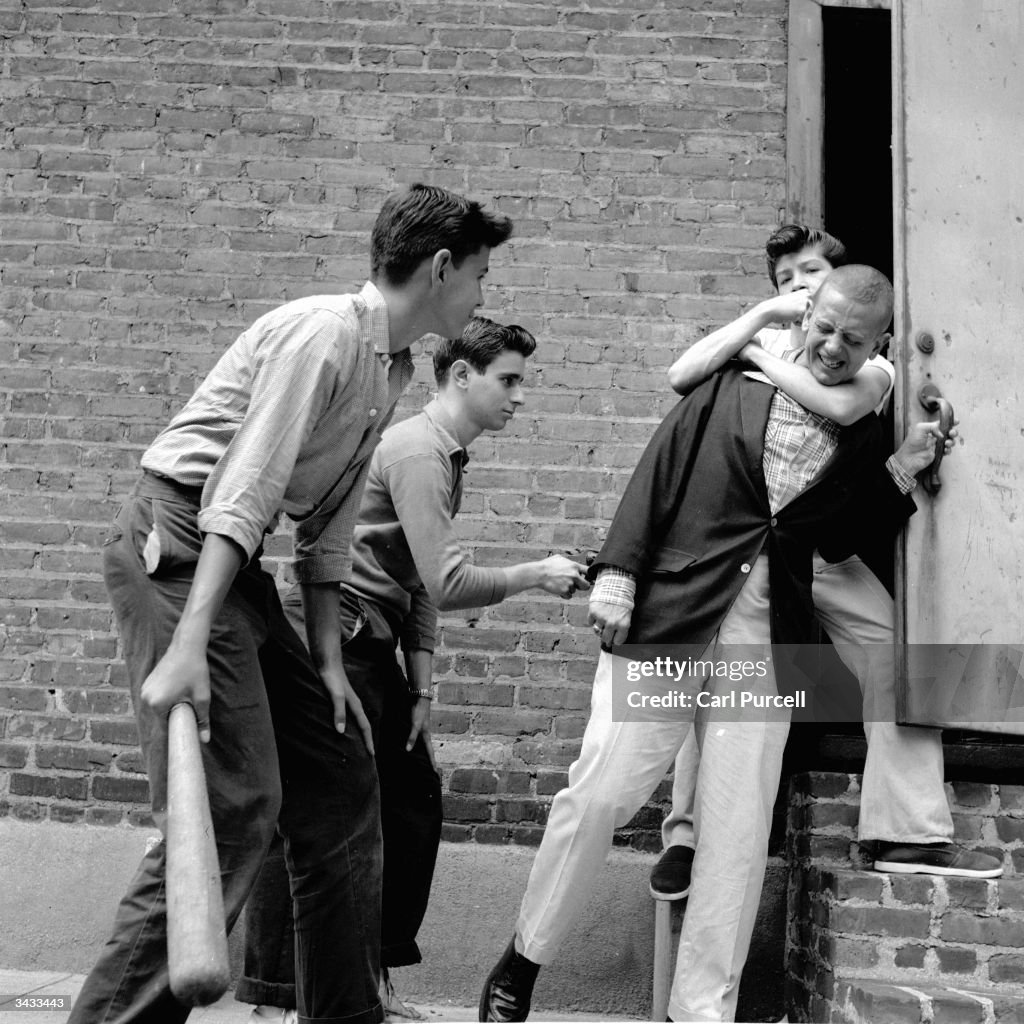 A teenage street gang carry out a mugging in a deserted alley in New ...