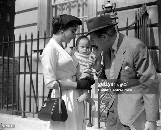 Film star couple Michael Wilding and Elizabeth Taylor with their eight-month-old son Michael Wilding Jnr outside their apartment in London's...