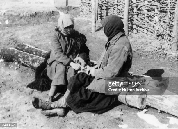 Two Russian women eat their rations during a serious famine.