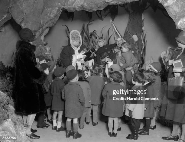 Group of young children pay a visit to the 'Land of Good Luck' in Selfridges, London to share their Christmas wishes with Santa and his elf.