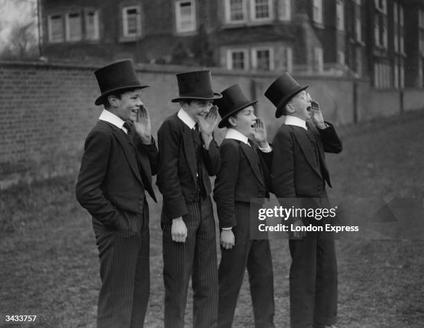 Group of public school boys watch their classmates playing the Eton Wall Game, traditionally played between town and school on St Andrew's Day, and...