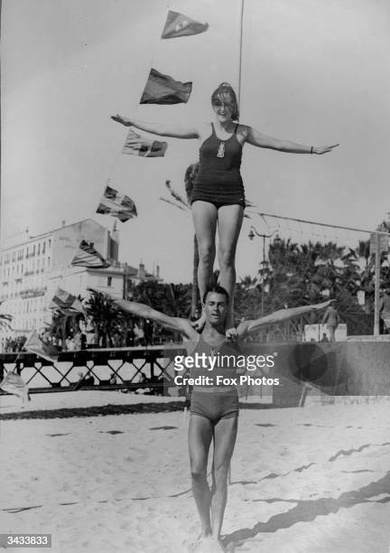Jean Rouma and partner do a balancing act on the beach at Cannes.