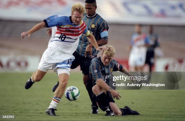 Mo Johnston of the Kansas City Wizards dribbles around Joe Franchino of Los Angeles Galaxy during a game at the Rose Bowl in Pasadena, California....