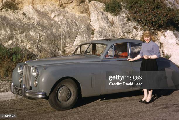 Roberta Cowell resting standing beside her car in the south of France. Roberta was once a Spitfire pilot, prisoner-of-war, racing motorist,and has...