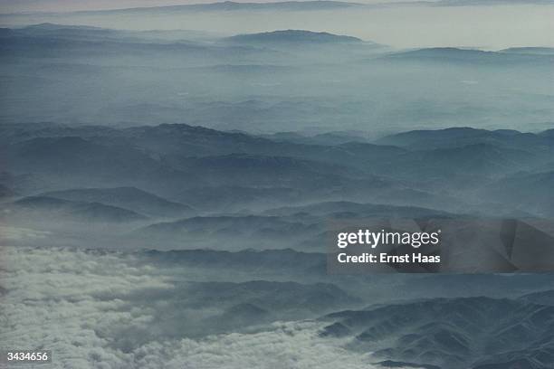 Mountains around Los Angeles seen from a plane. The misty, wave like appearance of the mountains is due to city smog ! Image Appears - HaasCD...