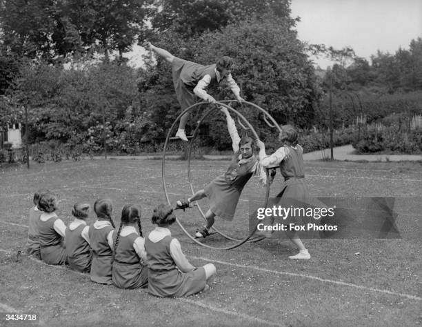 Crouch End High School girls using an exercise wheel in an open air gym lesson.