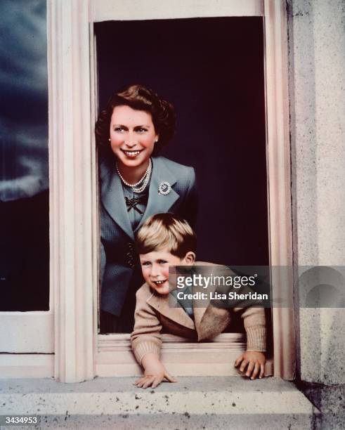 Prince Charles and his mother Princess Elizabeth looking out of a window at Balmoral.