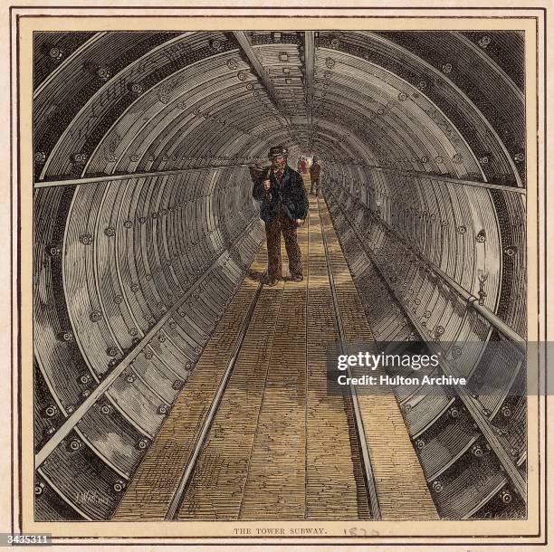 Pedestrians pass beneath the River Thames in London by means of the Tower Subway, a foot tunnel seven feet in diameter built by Peter Barlow between...