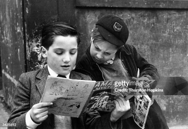 Two young boys reading comics. Original Publication: Picture Post - 5861 - Should US Comics Be Banned? - pub. 1952