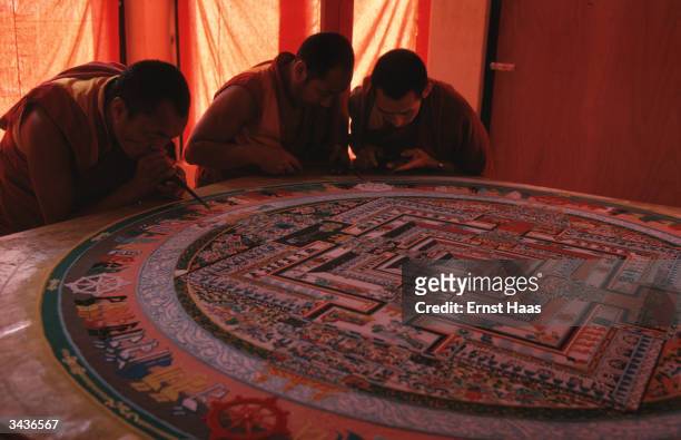 Artist monks constructing the Kalachakra mandala which is made with coloured sand. The mandala acts as an aid to meditation during the Kalachakra...
