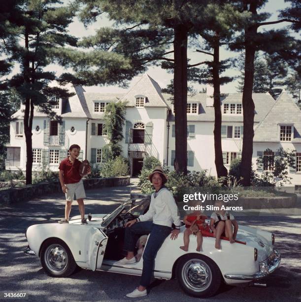 Mrs Henry Cabot Jnr with her children Henry Bromfield Cabot III, Camilla Foote Cabot and Andrew Hull Cabot, sitting on a car in the driveway of their...