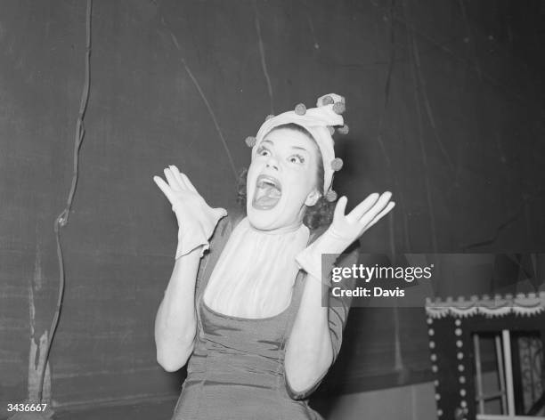 Showgirl Joan Heal wearing a clown hat and a comically startled expression.