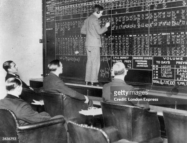 In a London club run by St Phalle Ltd, members watch fluctuations in the New York stock market during the Wall Street crash as changes are chalked up...