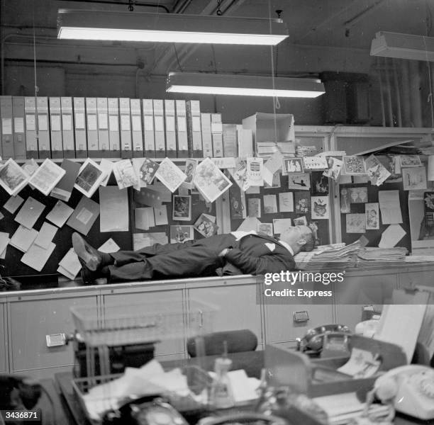 Evening Standard and Daily Express photographer Terry Fincher asleep in the office.