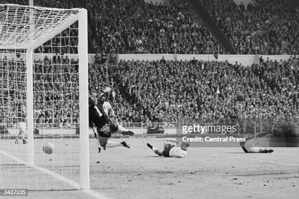 Geoff Hurst scores a third goal for England during the World Cup Final match against West Germany at Wembley Stadium. The ball hit the crossbar and...