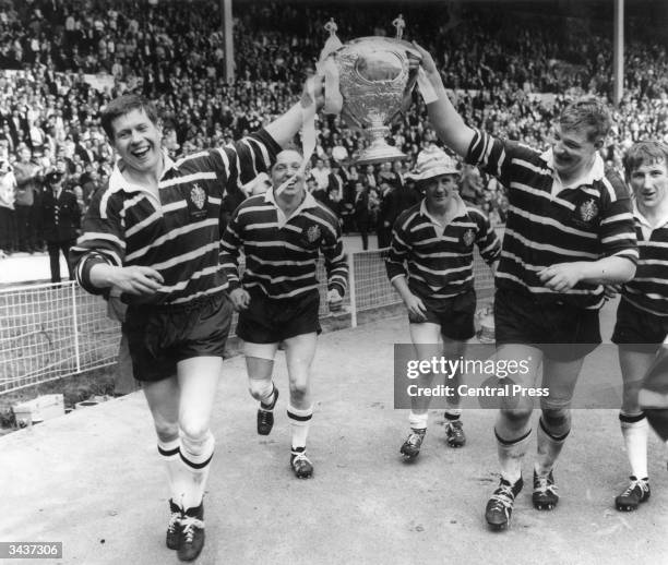 Featherstone Rovers captain, Malcolm Dixon holds the Rugby League Cup aloft with the help of a team mate after they had beaten Barrow at Wembley...