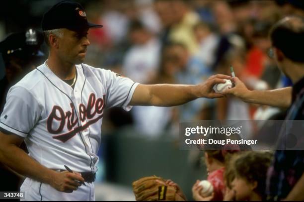 Infielder Cal Ripken Jr. #8 of the Baltimore Orioles signs autographs during a game against the Oakland Athletics at the Camden Yards in Baltimore,...