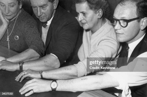 Survivors of Auschwitz concentration camp display the camp markings still on their arms. Dr Brenda gave evidence against former Auschwitz camp doctor...