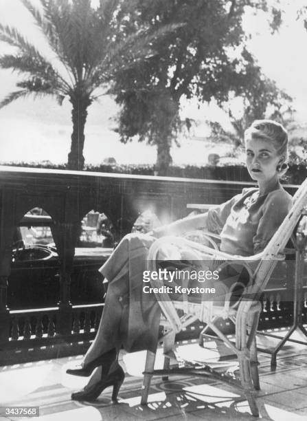 American socialite and Woolworth heiress Barbara Hutton , the Countess von Haugwitz-Reventlow, relaxes on the balcony of the Mena House Hotel in...