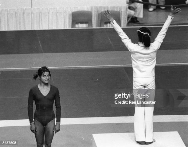 Romanian athlete Nadia Comaneci celebrating her gold medal for the beam at the Montreal Olympics, while the silver medal winner and Russian athlete...