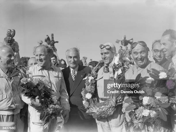 British racing driver Reg Parnell , Italian driver Giuseppe Farina and Italian C Fagioli, members of the victorious Alfa Romeo team at the finish of...