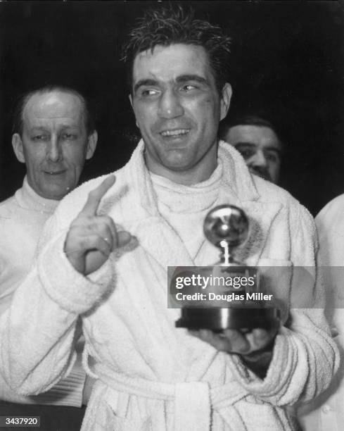 American boxer Joey Maxim with the light-heavyweight boxing trophy after he had knocked out Freddie Mills in the tenth round at Earl's Court.