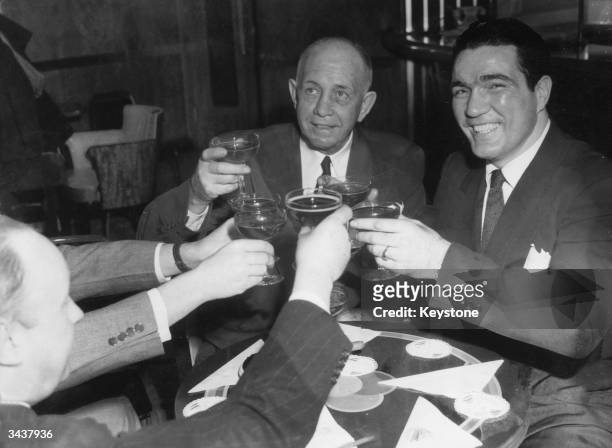 American boxer Joey Maxim and his manager 'Doc' Hearns being toasted by sports writers upon their arrival in New York after Maxim won the World...
