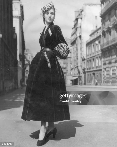 'Prince Igor', a Christian Dior design of full skirted green velvet coat with tight belt, gold and silver embroidery over slant pockets and deep...