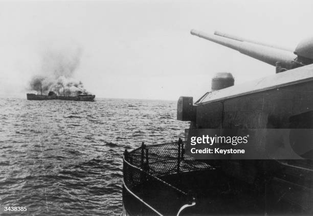 View of the German battleship Bismarck firing on a merchant ship in the north Atlantic. The Bismarck was sunk after attack by the British fleet on...