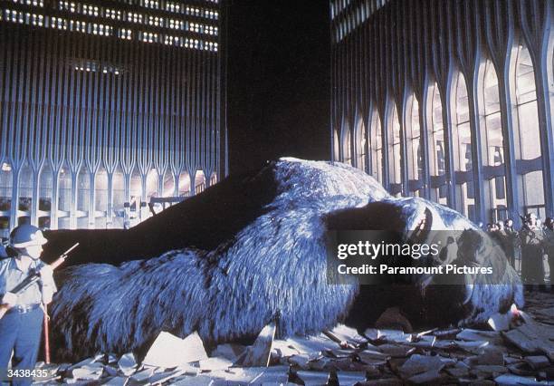 National Guardsmen stand around the wounded giant gorilla as he lies in a pile of rubble between the Twin Towers of the World Trade Center in a still...