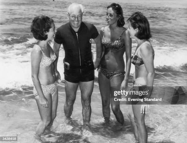 Australian prime minister Harold Holt on the beach with three women.