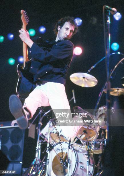 The Who's guitarist Pete Townshend leaps into the air during a performance.