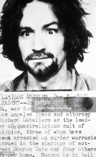 Police mug shot of American cult leader and murderer Charles Manson. Information about the Tate-LaBianca murders is detailed below the photo.