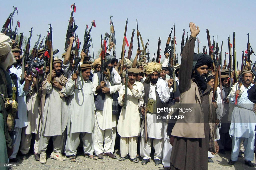 Pakistani tribesmen raise their red-ribb