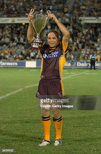 Gorden Tallis of the Broncos holds the XXX Cup aloft after the NRL match between the North Queensland Cowboys and the Brisbane Broncos at Dairy...