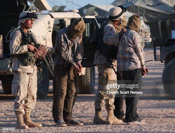 Army soldiers from Alpha Company of 1st Battalion, 14th Regiment of the 25th Infantry Division lead away detainees suspected of being illegal...