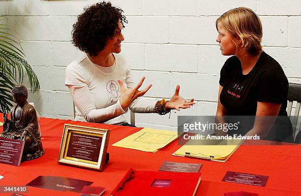 Feng Shui consultant Cheryl Janis talks with a guest during Step Up Women's Network's Third Annual "Step Up For Yoga and Health" charity festival at...