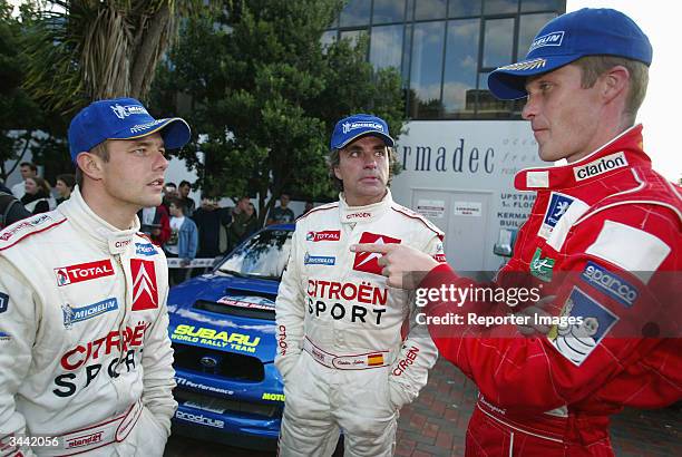 Sebastian Loeb of France and Carlos Sainz of Spain talk with Harri Rovanpera of Finland during the third day of the WRC Rally of New Zealand on April...