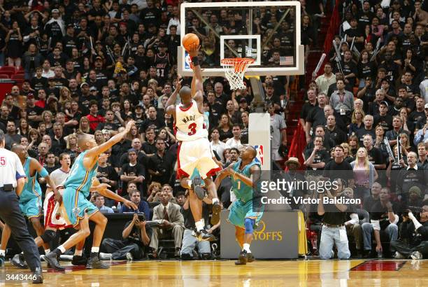 Dwyane Wade of the Miami Heat makes the game winning shot as Baron Davis of the New Orleans Hornets looks on during the 2004 NBA Playoffs on April...