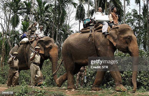 Indian security personnels escort election officials transporting Electronic Voting Machines on elephants leaving to polling stations of the Guwahati...