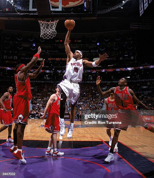 Vince Carter of the Toronto Raptors goes up for a dunk against Eddy Curry of the Chicago Bulls during a game at Air Canada Centre on April 11, 2004...