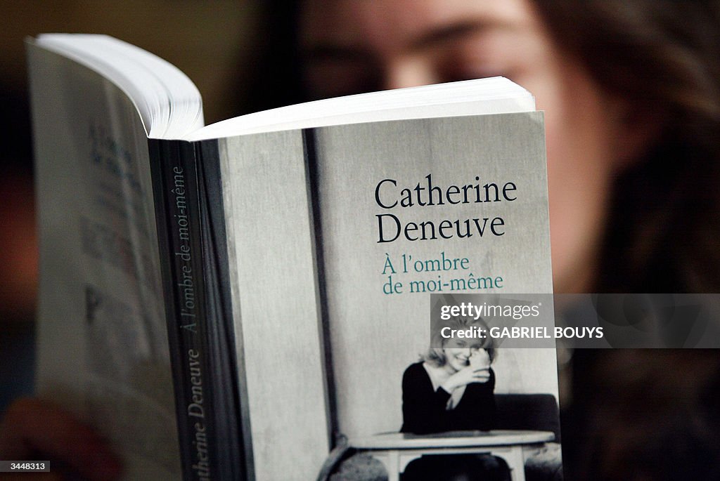 A woman reads French star Catherine Dene