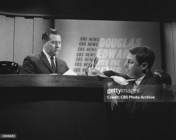American broadcast journalist Douglas Edwards sits behind the news desk and talks to CBS News director Don Hewitt, on the set of CBS News, November...
