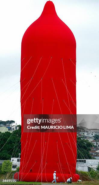 Two workers give the finishing touches to the world's biggest condom, in Sao Paulo, Brazil, 20 April, 2004 made by Brazilian artist Degmar Covos, as...