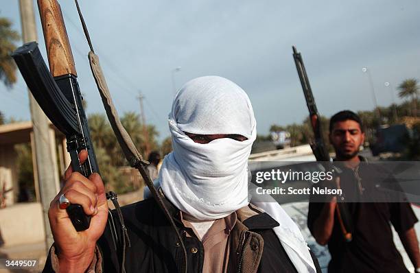 Armed soldiers of the Al-Medhi Army man a traffic checkpoint April 20, 2004 at the entrance to Kufa just outside the holy Iraqi Shia City of Najaf....